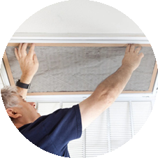Technician performing HVAC maintenance by replacing an air filter in a ceiling vent, ensuring optimal indoor air quality and system efficiency.