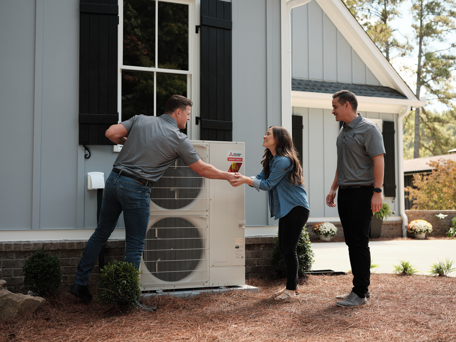 Technician assisting homeowner with HVAC system installation outside a residential property in Ocean City, MD.