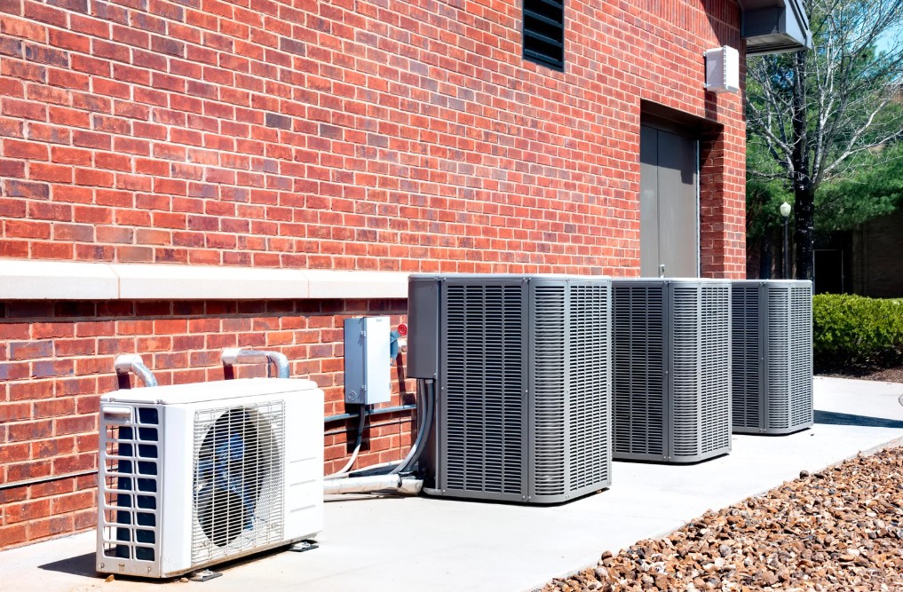 HVAC units installed outside a brick building, showcasing modern air conditioning and heating systems for efficient home comfort in Ocean City, MD.